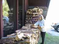 Mary, the one of the innkeepers at the Birch Ridge Inn at Killington, stacking wood for the fall and winter season.