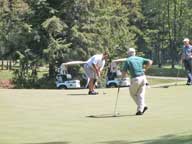 =Teddy Arbo rolls in an 8 foot par on the 18th hole at Green Mountain National, while playing partners Ted Olencki and Doc Humphries look on.