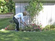 Mary cutting back the garden for winter at the ski shed at Birch Ridge.