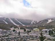 Killington Peak, covered in snow and clouds with a sliver of blue sky above.