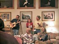 Christmas Caroling at the Glucks
Foreground : Hostess Noel Gluck with guest Charlotte Lange
Background: Guest Rich Rzasa on Guitar, Nina Tasi and Host Dick Gluck
Out of frame on left : George Lyons leading the party in song.