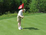 Peter Lynch looking in the cup for his ball on Hole #7,at Green Mountain National Golf Course