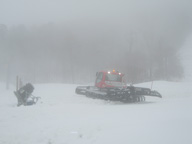 =Snow grooming machine working the the snow in front of Superstar Quad.