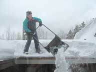 Pushing knee deep snow off the roof at the Birch Ridge Inn at Killington